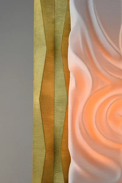 Close-up of textured fabric with wavy patterns in green, brown, and orange.