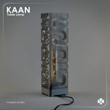 Gray textured table lamp with 'KAAN' branding on a gray background with the light turned of. Created by MODEO Design