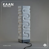White matte textured table lamp with 'KAAN' branding on a gray background with the light turned of. Created by MODEO Design