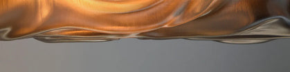 Glass sculpture with wavy design on a gray background